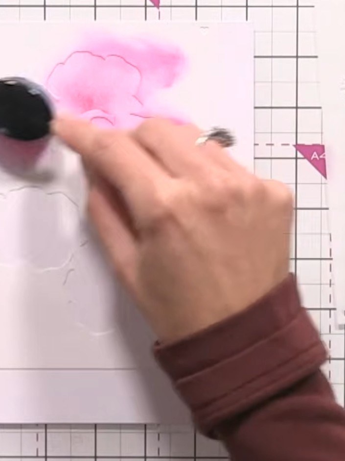 Step 3: Position the second stencil layer over the stamped image and apply dark pink ink using a blending tool. Press 