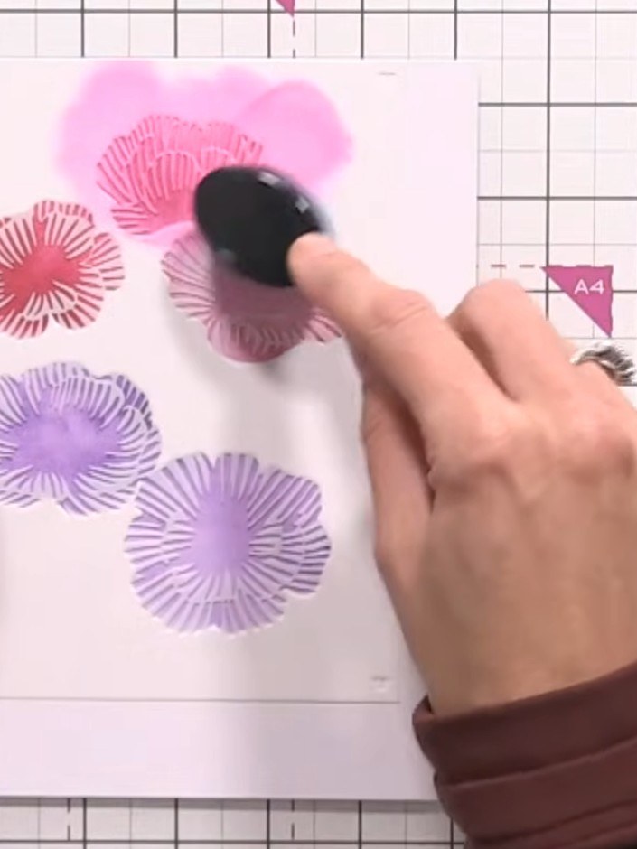 Step 4: Apply purple ink through the third stencil layer, blending it slightly with the pink areas to create a reddish