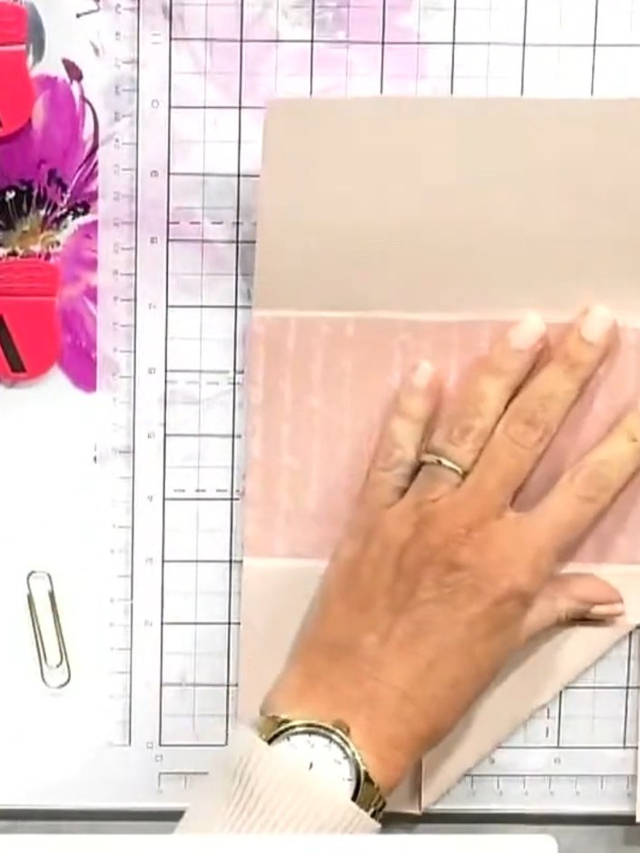 Step 8: Fold the bottom corners of the vellum pocket upwards and back to create triangular flaps that will help hold i