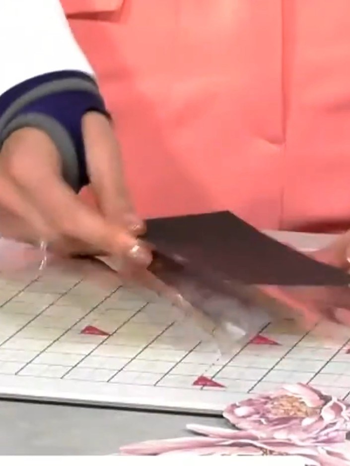Step 5: Position the patterned paper behind the acetate window panel so that the design is visible through the clear a