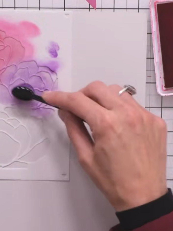 Step 5: Position the third stencil layer over the bottom flower and apply teal ink using a pouncing motion with your b