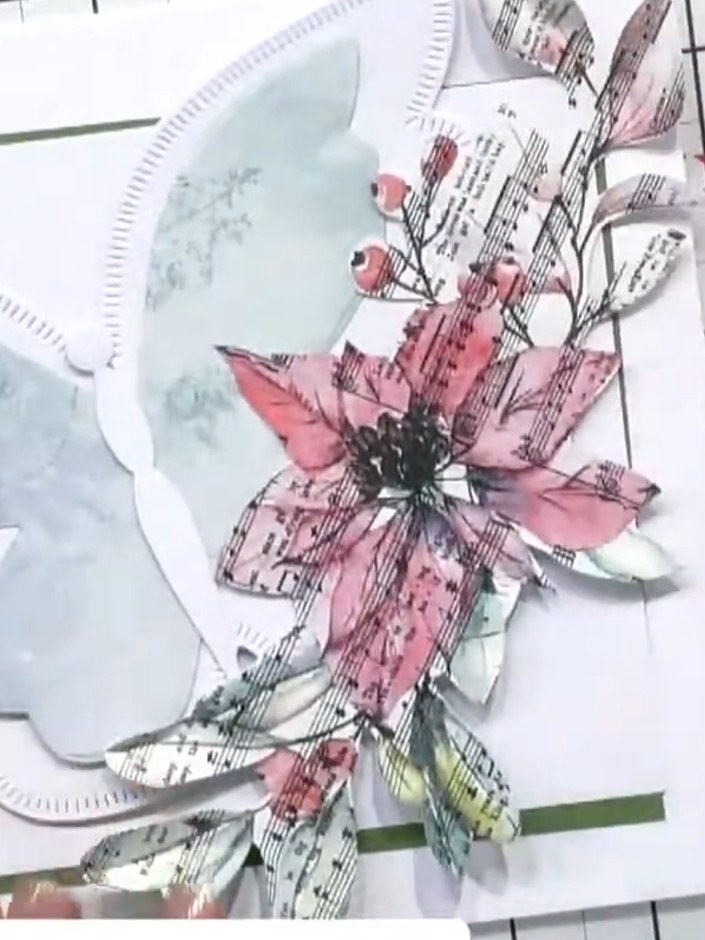 Step 4: Attach the layered poinsettia embellishment onto the front of your green card base using adhesive. Position it