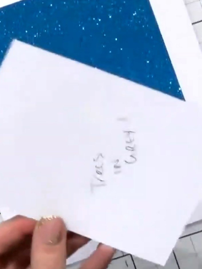 Step 1: Start with a white top-folding note card base. The card features a blue glittery triangular design at the top.