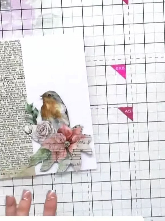 Step 6: Position and adhere the fussy-cut robin image onto the newspaper print panel, placing it to one side rather th
