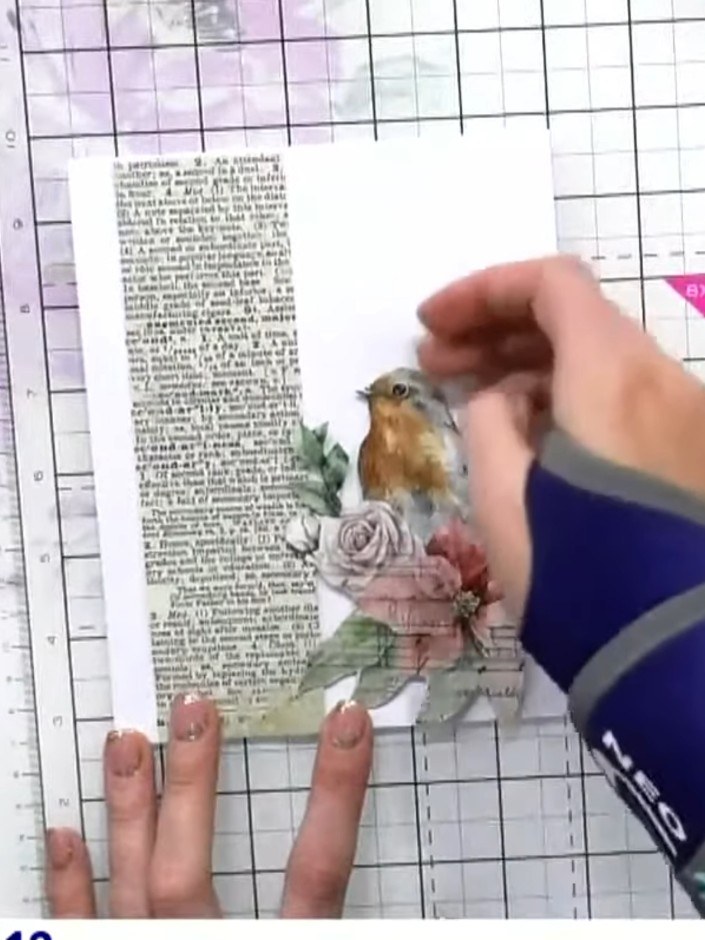 Step 7: Attach the green foliage tail piece behind the robin using foam pads, positioning it to extend from the lower 