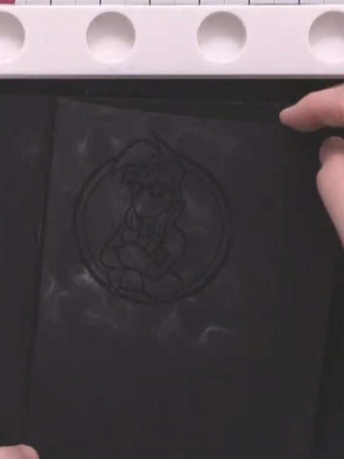 Passo 2: Apply embossing ink over the stamped character image using an embossing ink pad or applicator. Ensure the enti