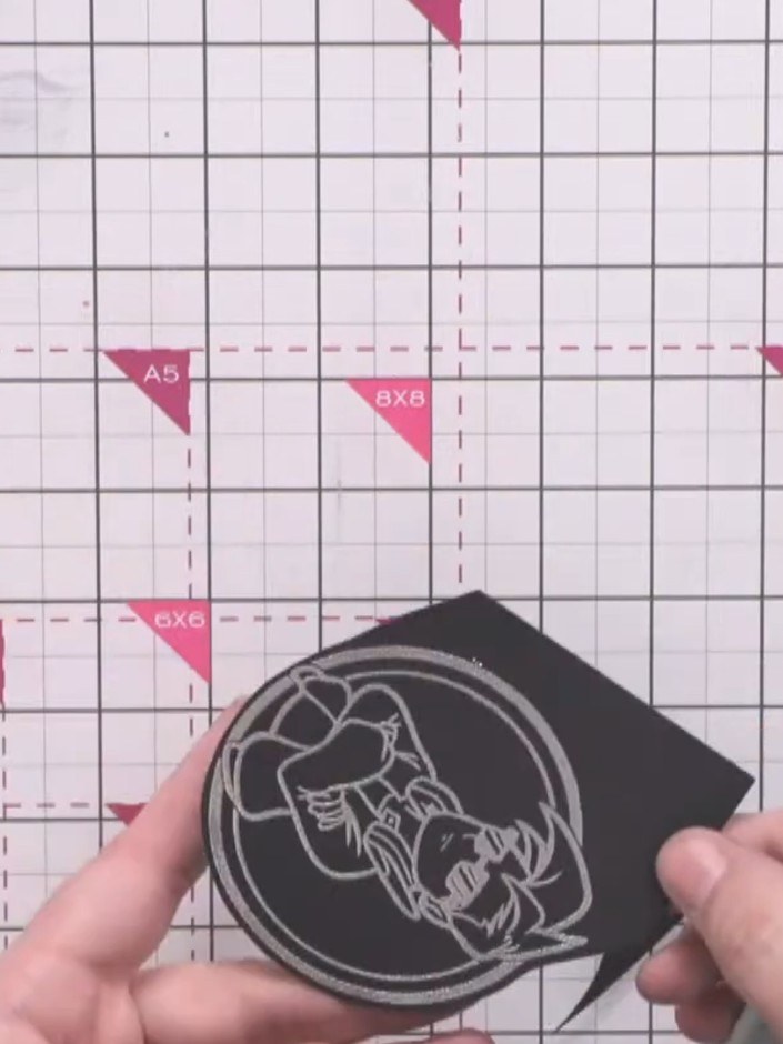 Passo 6: Trim around the embossed character design using scissors, leaving a slight border of black card around the edg