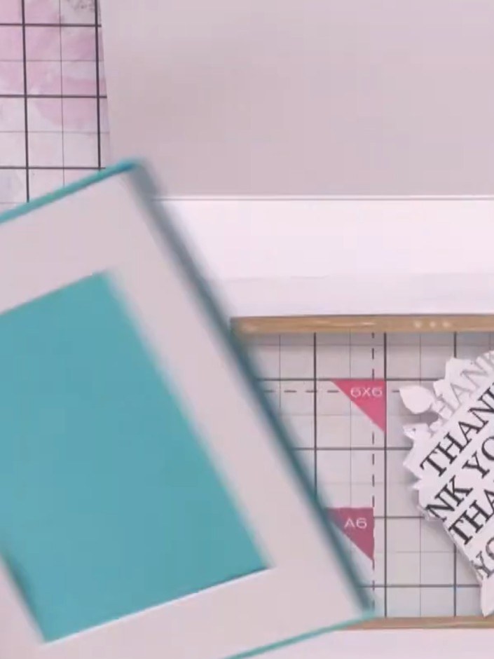 Passo 15: Adhere the smaller teal frame onto the 6x6 inch teal cardstock piece to create a layered backing panel for you