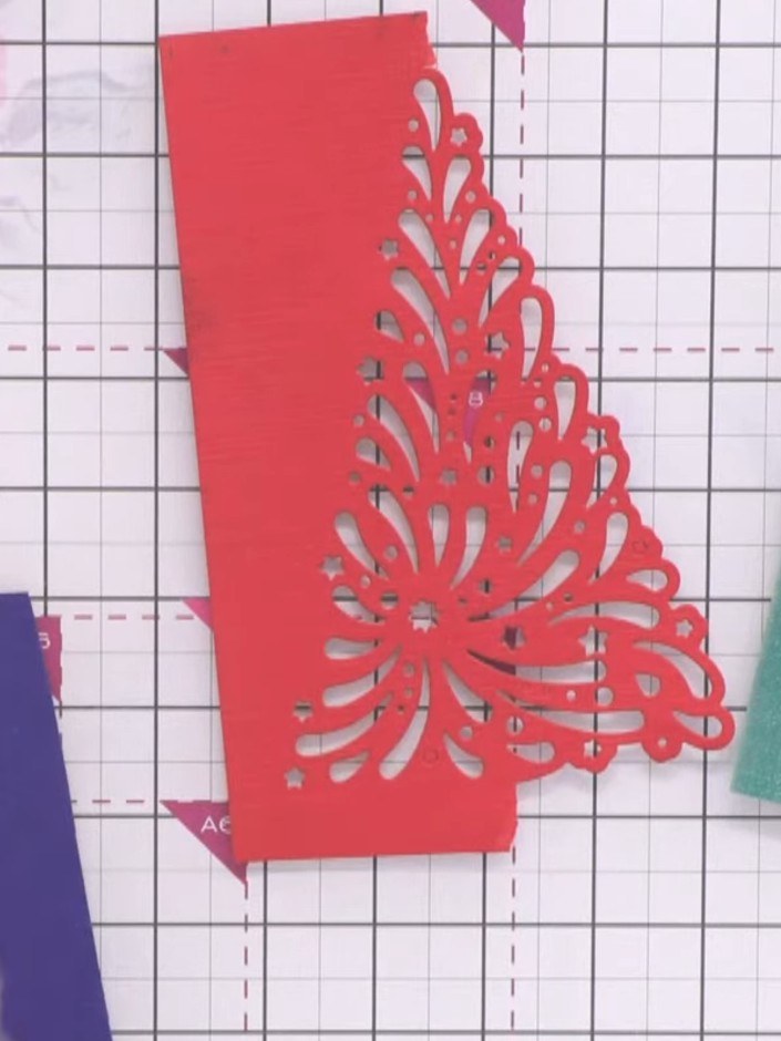 Passo 4: Die-cut the decorative Christmas tree design from red cardstock. Repeat with purple cardstock to create a seco