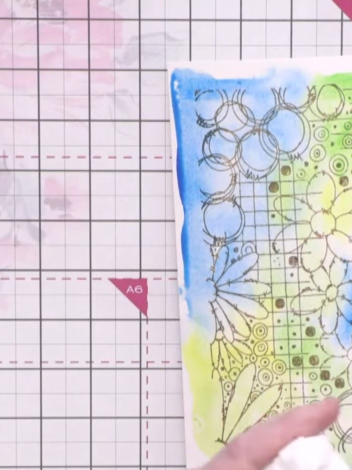 Passo 6: Lightly colour in some of the stamped flowers and circles with watercolour, leaving other areas uncoloured to 