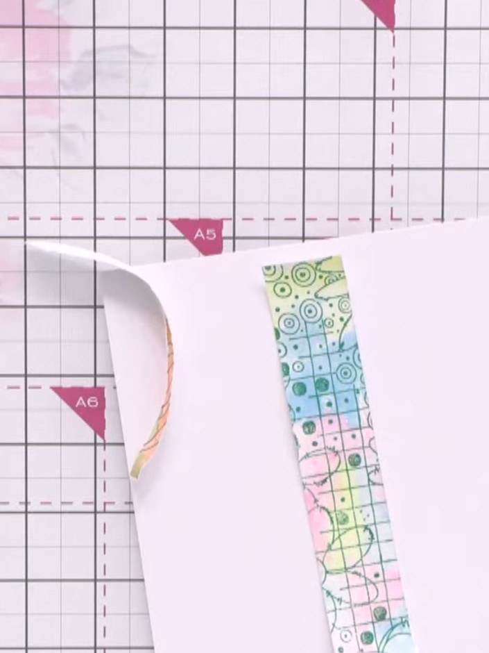 Passo 9: Arrange and glue the torn decorative paper pieces onto the watercolour background in a collage style, leaving 