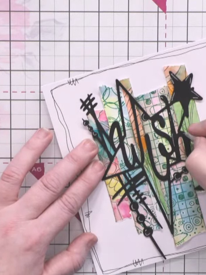 Passo 5: Position the completed wish die-cut with the colourful patterned paper and black star embellishments onto your