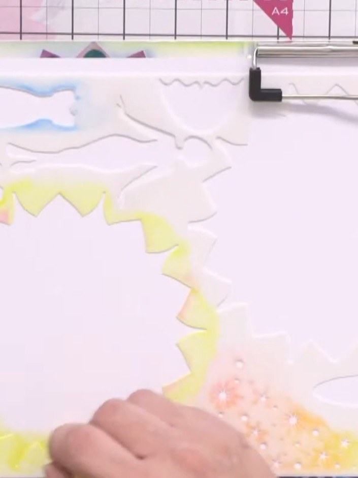 Stap 4: Apply yellow ink through the stencil opening around the central area, building up the layered mandala effect. 