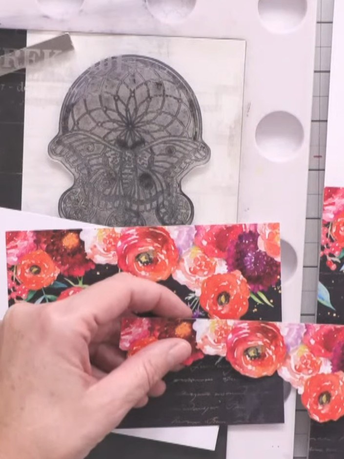 Passo 2: Trim the floral patterned paper to fit across your black card base, leaving some of the black showing at the e
