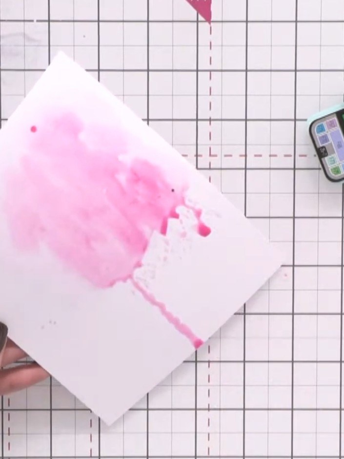 Stap 5: Mix a tealy blue colour and add it to the wet area on your card. Allow the blue to blend with the pink, creati
