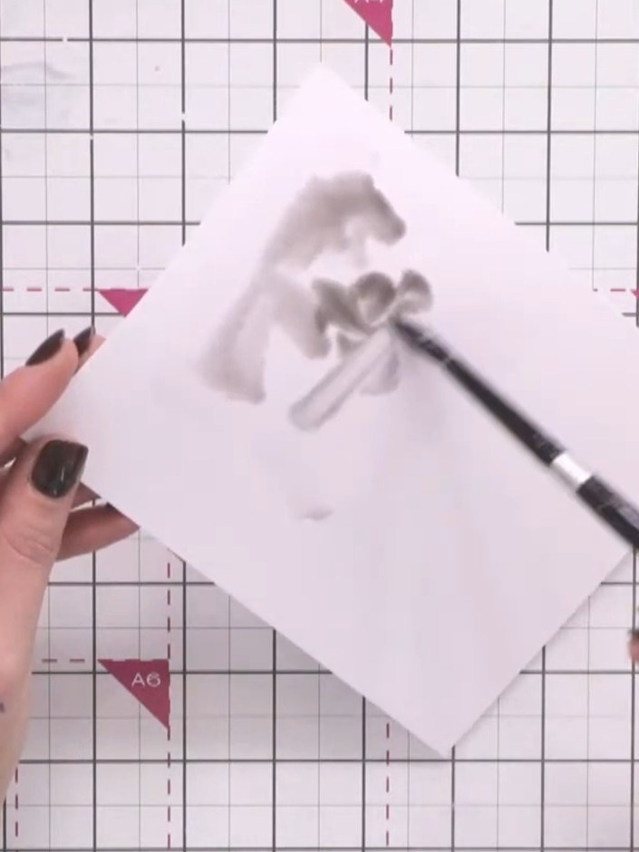 Passo 2: Mix a small puddle of black watercolour paint on your palette or mixing surface. Use a brush to blend the pain