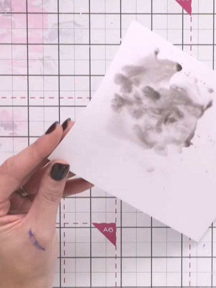 Passo 3: Drop black paint into the wet area on your card. Splat water onto the paint to create drips and movement acros