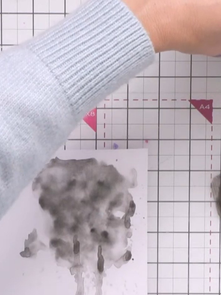Passo 6: Mix white paint with water to create a diluted mixture. Use a fine liner pen or brush to add splats and lines 