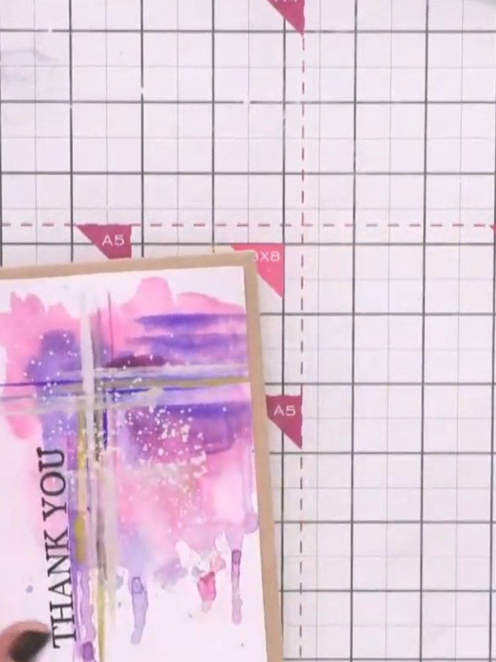 Paso 8: Add a sentiment stamp to your card. Position the 'THANK YOU' text vertically along the left side of the waterc