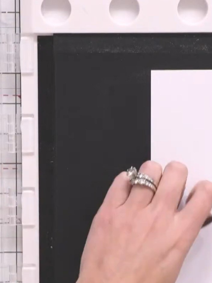 Passo 3: Without moving the stamp or platform, carefully remove the first piece of white cardstock. Replace it with a s
