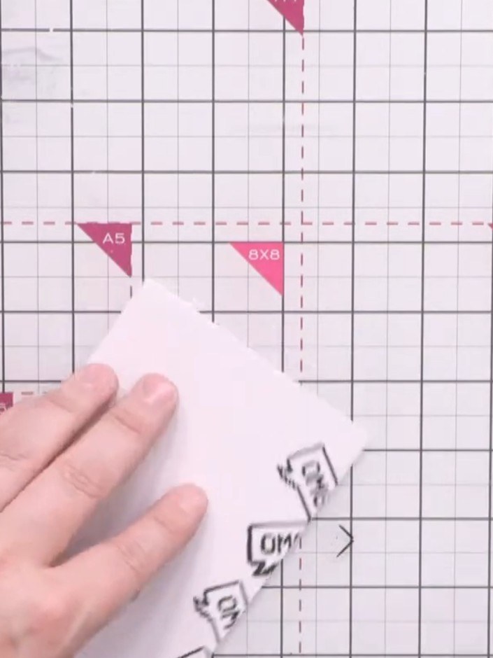 Passo 14: Stamp a small word stamp (such as 'OMG') around all four edges of the white card blank using black ink to brea