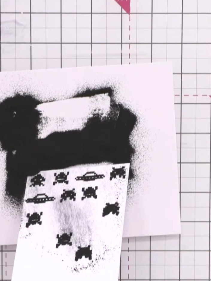 Passo 5: While the ink is still wet, generously sprinkle black embossing powder over the stamped alien images. Tap off 