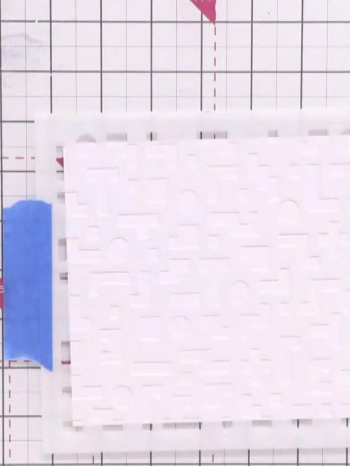 Paso 1: Pre-cut a piece of white card to approximately 5¾ inches square. Secure the card to your cutting mat using mas