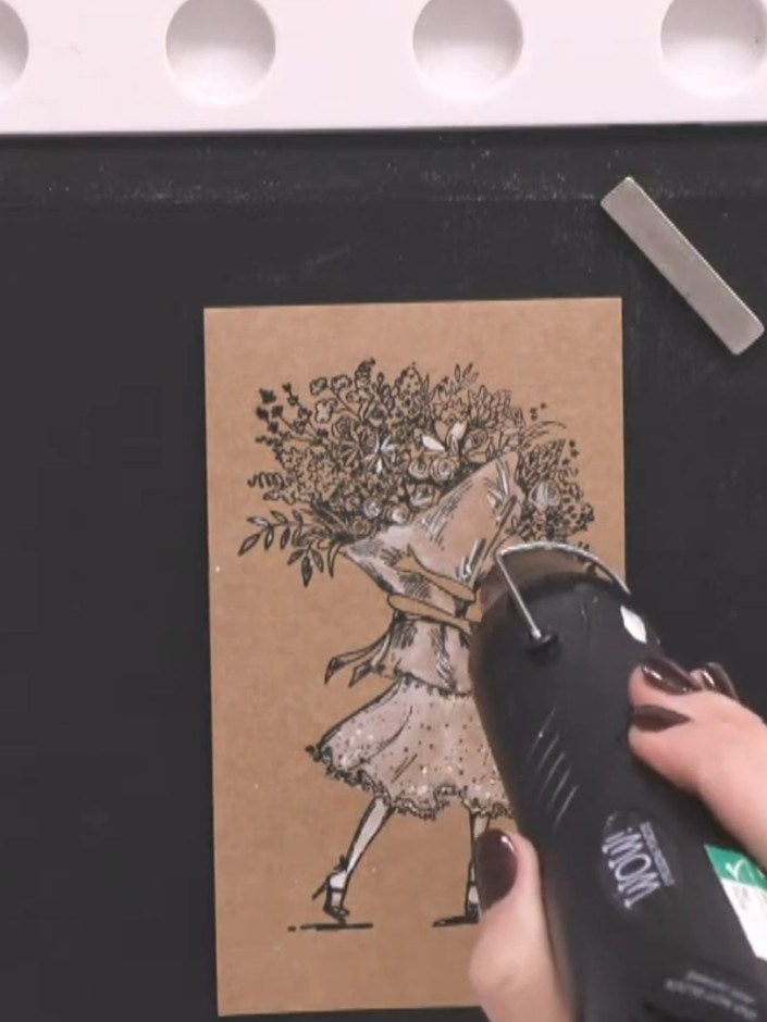 Passo 8: Apply clear sparkle or glitter to the flower bag using a heat tool or applicator to create a subtle highlight 