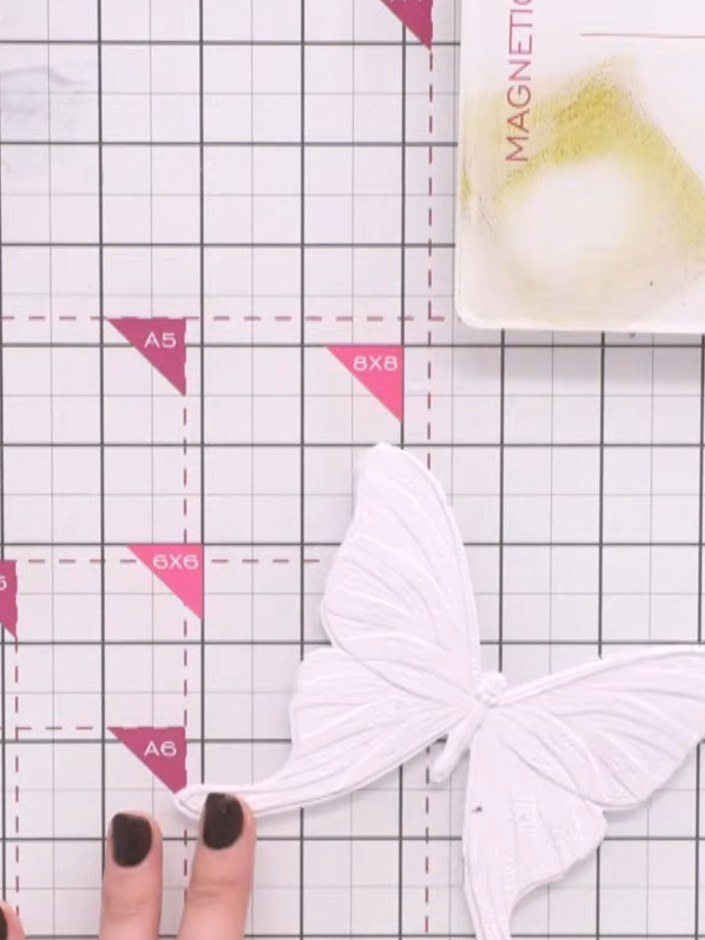 Passo 6: Position your die-cut butterfly on the painted background. Apply watercolour washes using brown and orange ink