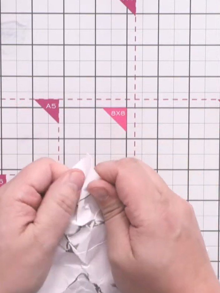 Step 6: Run an anti-static bag over the grey embossed lines on the crumpled paper to protect them from the next step. 