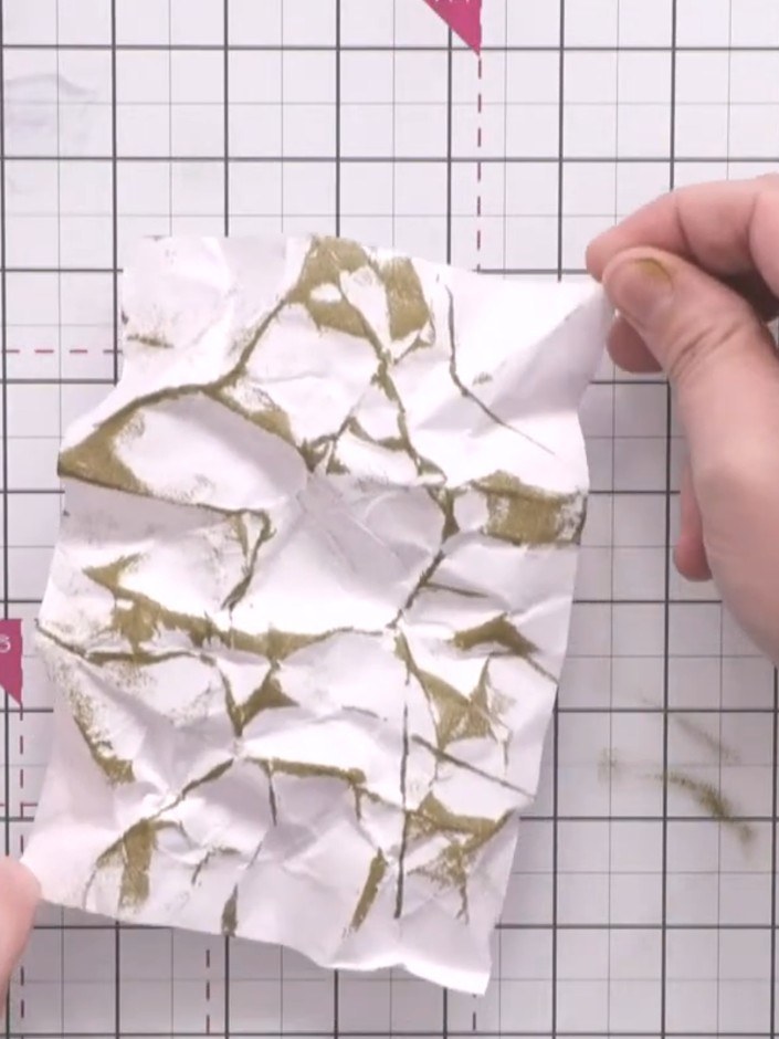 Step 9: Sprinkle gold embossing powder generously over the crumpled paper where you've applied the embossing ink. Ensu