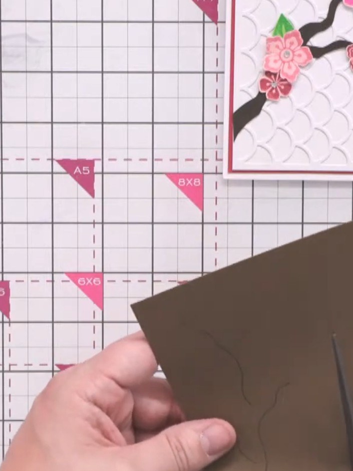 Passo 10: Use scissors to carefully cut along your drawn lines on the brown cardstock, creating wavy edges for a natural