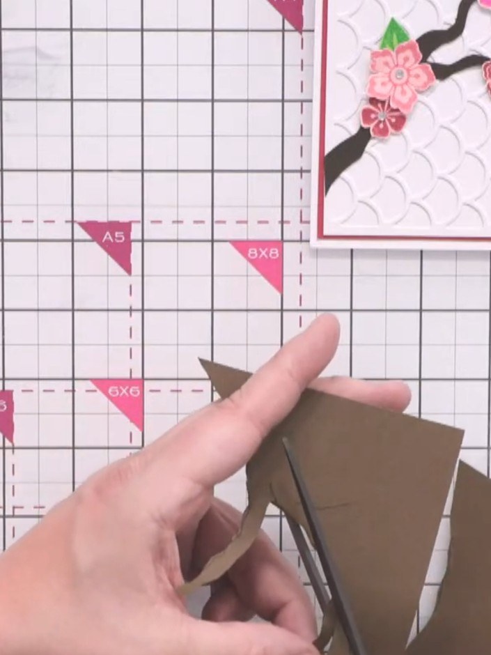 Passo 11: Glue the brown branch piece onto your card, curling it slightly to add dimension. Position it carefully to cre
