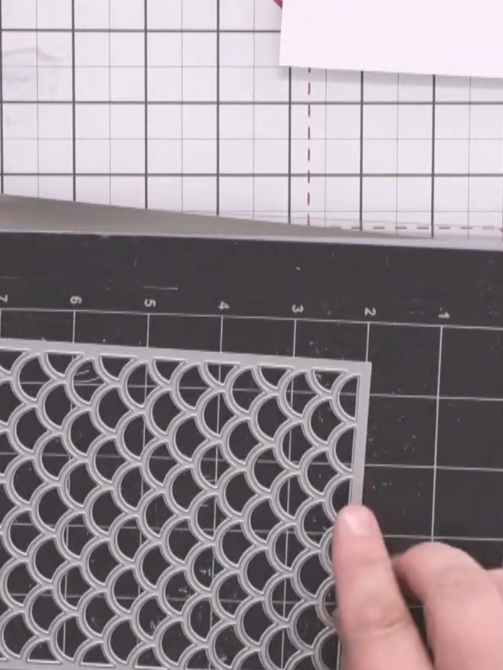 Passo 2: Posiziona la fustella Stylish Scales su un tappetino magnetico, con sotto uno dei pezzi di cartoncino bianco.