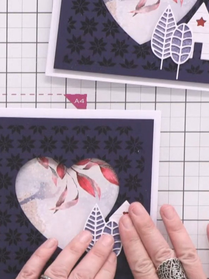 Step 10: Assemble all elements onto the navy patterned card base. Position the white decorative leaf die-cuts in the bo