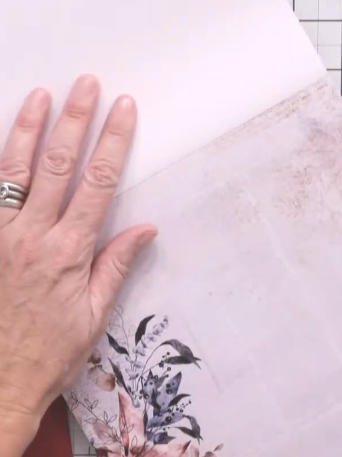 Step 5: Select a patterned paper from the White Magic paper pad and position it behind the heart aperture on the navy 