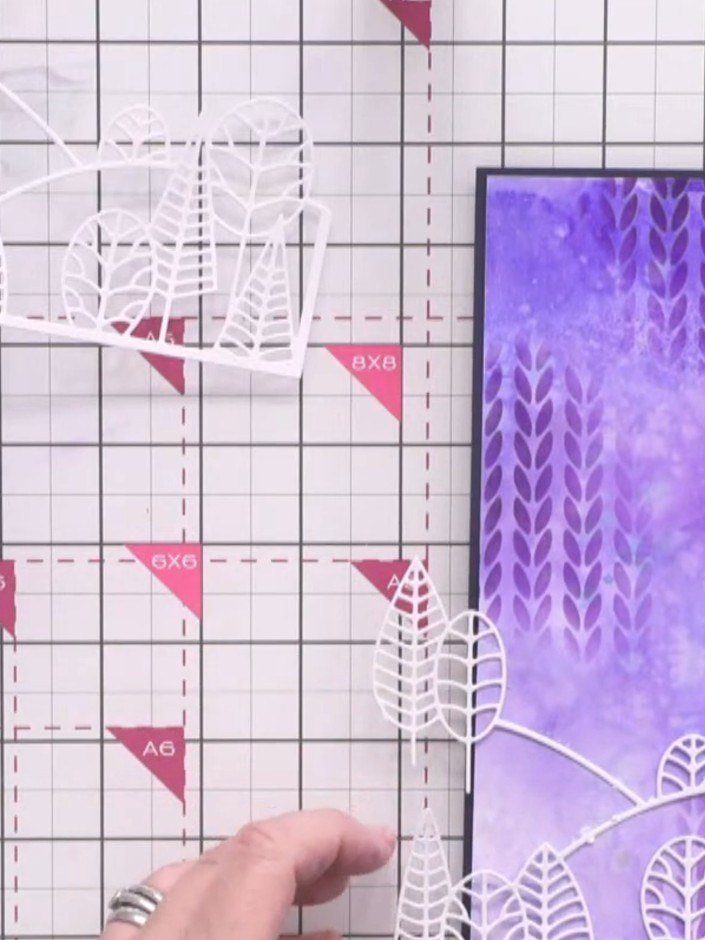 Step 10: Carefully trim away the upper portion of the white die-cut leaf scene, keeping only the bottom hill section wi
