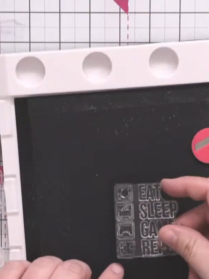 Step 1: Position the gaming icons stamp centrally on your black card square using your stamping platform. Use magnets 