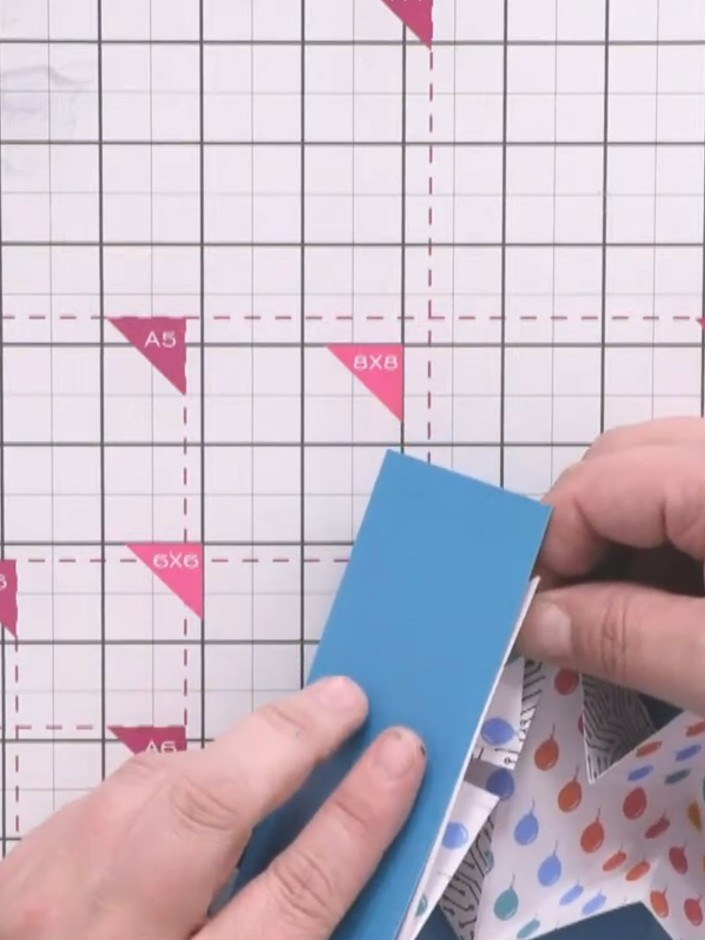 Step 13: Position the folded insert inside the blue gatefold card, using the card edges to hold it in place centrally. 