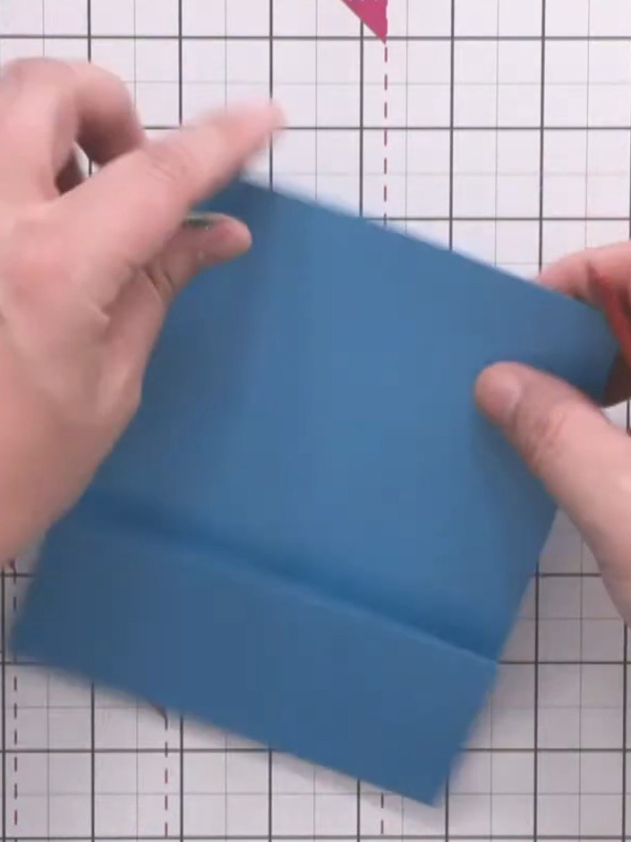 Step 3: Use a bone folder to crease along the score line, creating a sharp fold in the blue card blank.