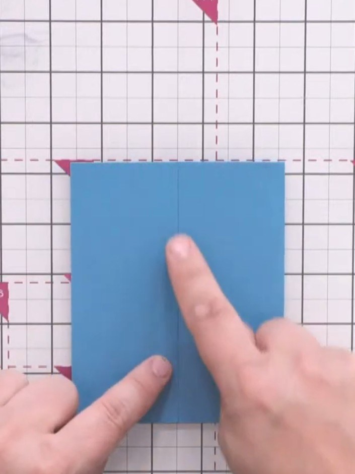 Step 5: Use the bone folder to crease the second score line on the blue card, creating a gatefold card blank.