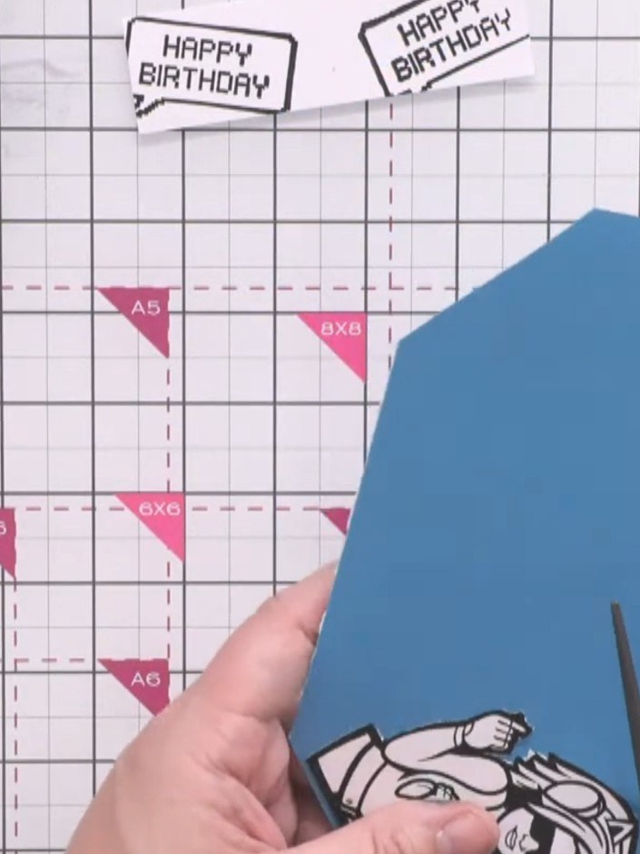 Step 5: Cut around the coloured character, leaving a small blue border visible around the stamped image. Take care whe