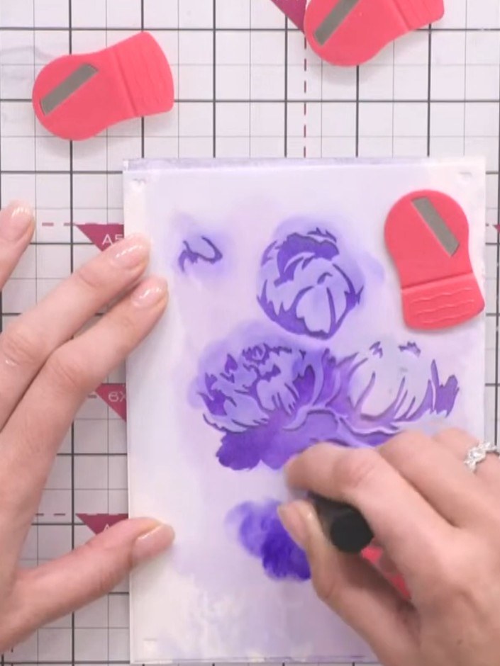 Step 8: Apply the same purple ink through the second stencil, pressing firmly to build up the layered floral design on