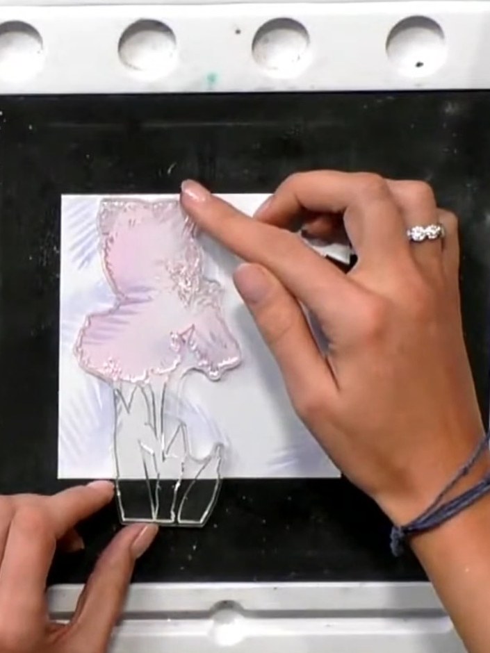 Step 7: Mount the completed iris design onto the stencilled feather background cardstock using foam pads or adhesive f
