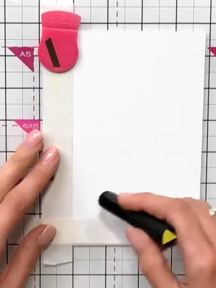 Step 1: Position a piece of white cardstock on your cutting mat. Use a Halo tool or masking tape to hold a section in 