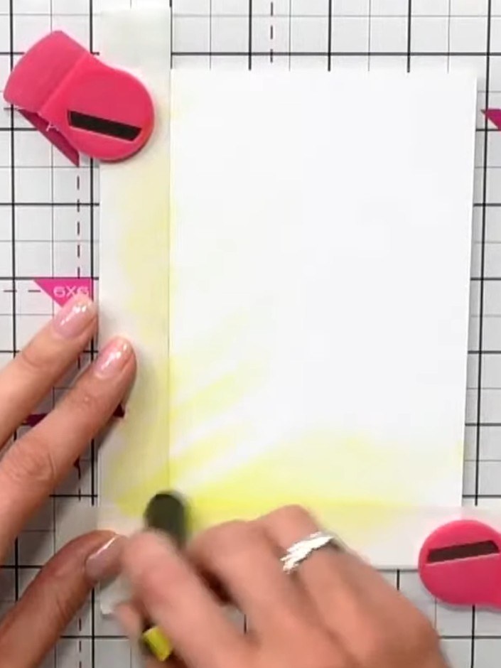Step 2: Lightly dust yellow ink around the edges of the masked area on the white card, working from the outside inward