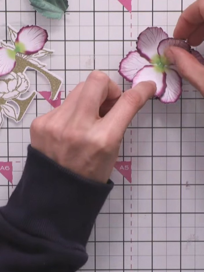 Step 11: Glue a small pink and white chrysanthemum flower into the lower portion of the card. Gently curl and twizzle t