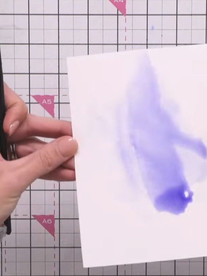 Step 5: Scrunch up tissue paper and press it into the wet purple paint to create texture and lift colour from the back