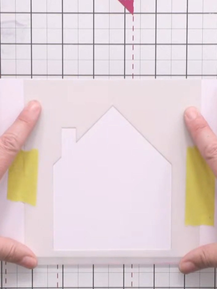 Step 1: Position the large house aperture stencil on white card. Secure it in place using small pieces of masking tape