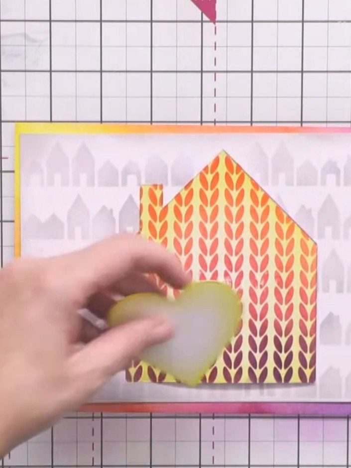 Step 10: Adhere the layered 'home' sentiment to the front of the card, positioning it over a small blended heart shape 